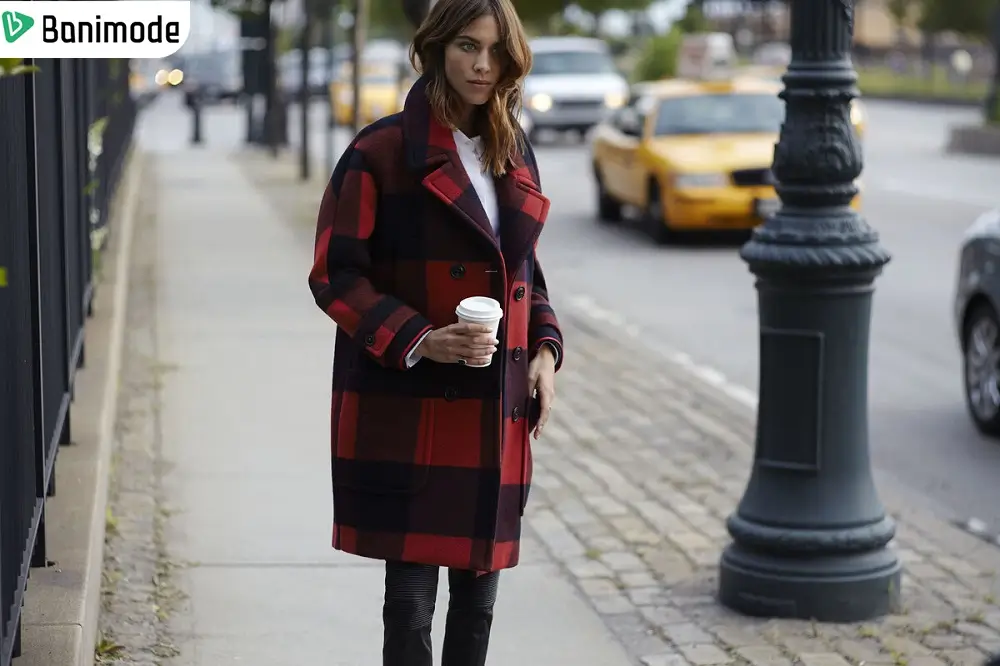 یک خانم که پالتو چهارخانه قرمز و مشکی پوشیده