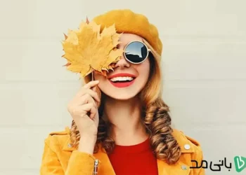 یک دختر با عینک آفتابی و برگ های پاییزی