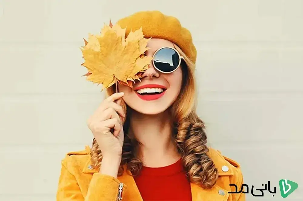 یک دختر با عینک آفتابی و برگ های پاییزی