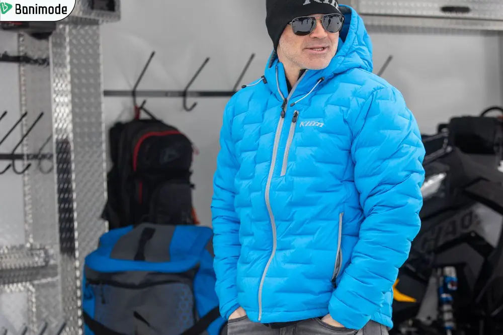 مردی که پافر آبی رنگ پوشیده و عینک آفتابی به چشم دارد.