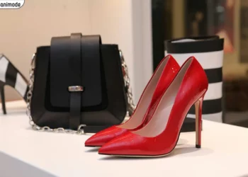 کفش پاشنه بلند زنانه قرمز رنگ در کنار کیف دستی زنانه مشکی رنگ